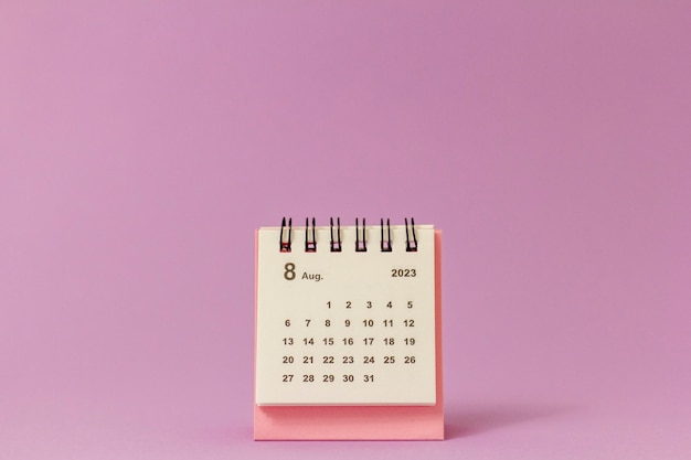 Desktopkalender voor augustus 2023 op een roze achtergrond