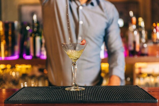 Deskundige barman maakt cocktail in de nachtclub.