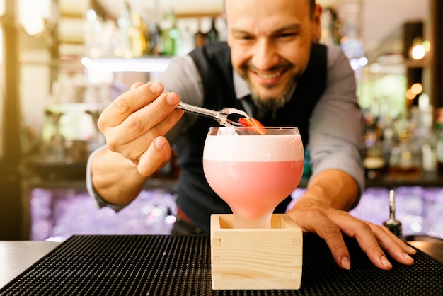 Deskundige barman maakt cocktail in nachtclub