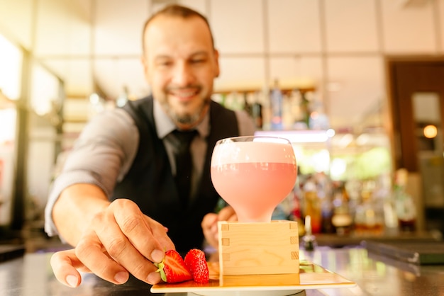 Deskundige barman maakt cocktail in nachtclub