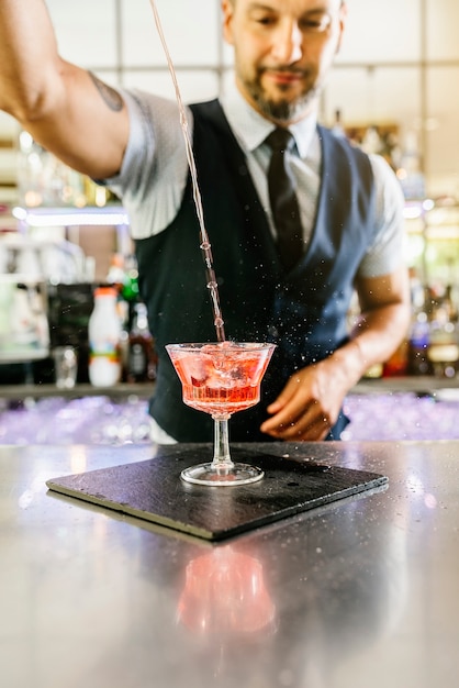 Foto deskundige barman maakt cocktail in nachtclub