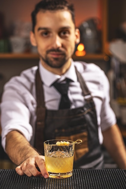 Deskundige barman serveert cocktail