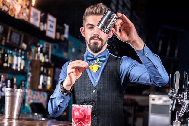 Deskundige bartending die verse alcoholische drank in de glazen in de nachtclub giet