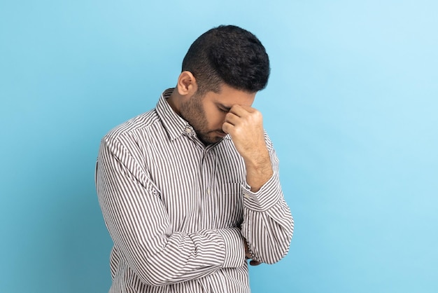 Desperate businessman rubbing tired eyes crying because of hopelessness and loneliness