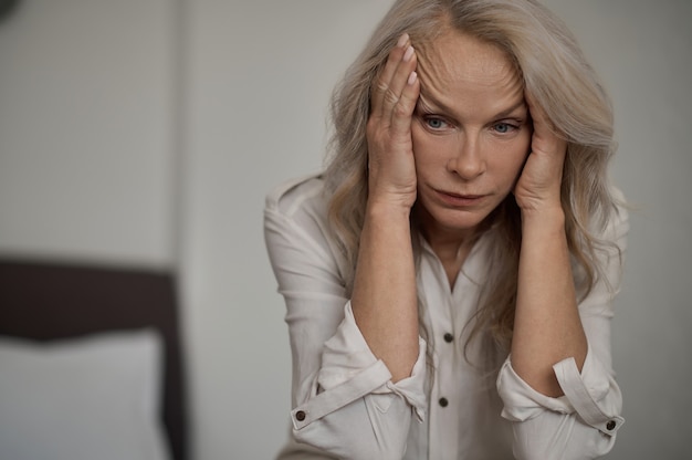 Despondent blonde mature woman suffering from loneliness