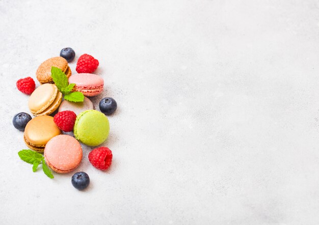 Macaron o maccherone del dessert con il lampone e il mirtillo sulla cucina di pietra. vista dall'alto.