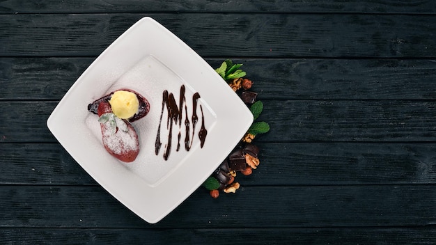 Dessert Caramelized pear with ice cream on a plate On a wooden background Top view Copy space