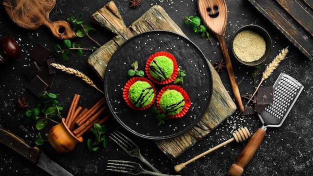 Фото Десерт. шоколадные зеленые пирожные с кокосовой стружкой. сладости. вид сверху. деревенский стиль.