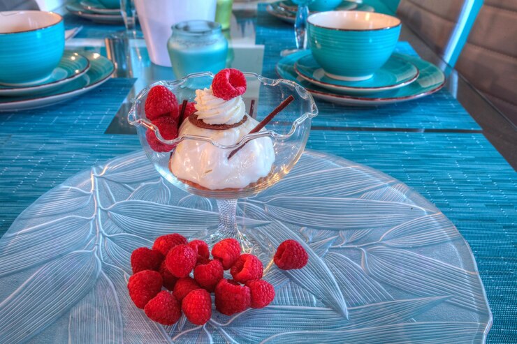 Photo dessert dish of cheesecake shaved chocolate and raspberries on a glass plate