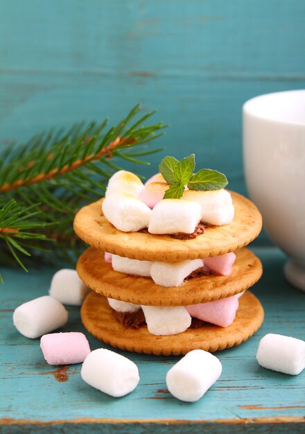 Dessert from cookies, chocolate and marshmallow on a blue background in the Christmas decor