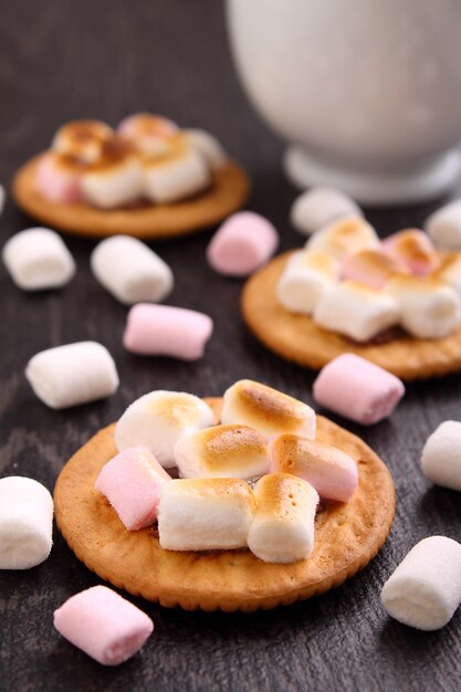 Dessert da biscotti con marshmallow su sfondo nero, decorazioni di natale