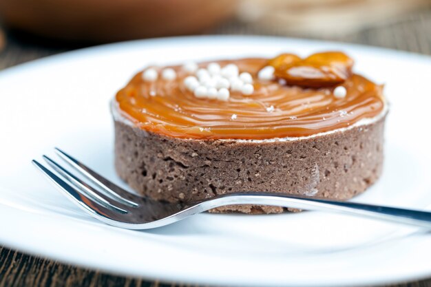 Dessert gemaakt van deeg en zuivelproducten in karamel, rond taartje met kwarkroom omhuld met romige karamel