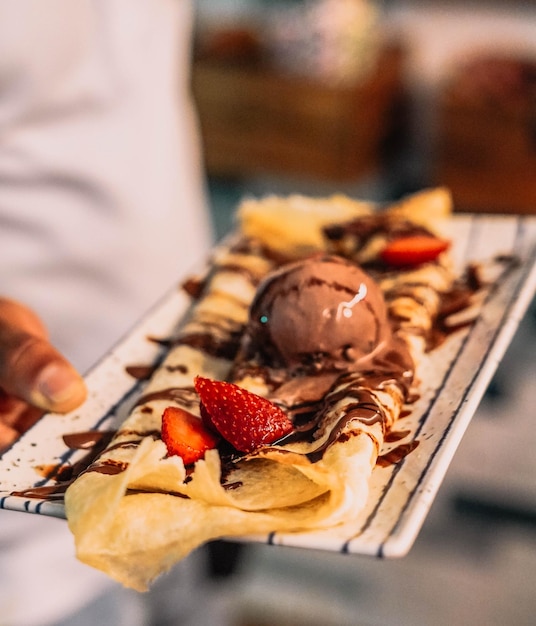 Dessert in een chique restaurant, in de vorm van worteltaart, crêpe en ijs.