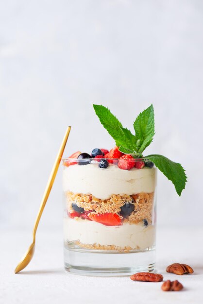 Dessert in een glas met bessen, muntschuim en koekje zonder suiker, gluten en lactose