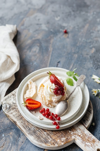 Dessert meringue with berries served on a wooden board