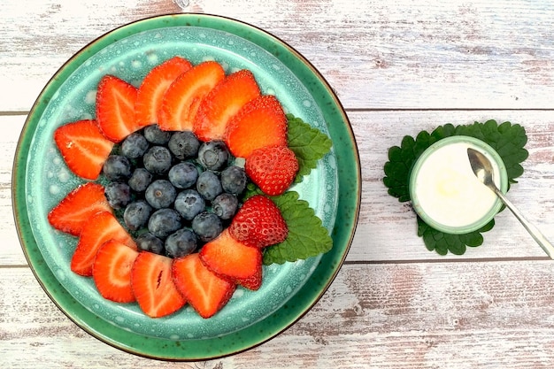 Dessert met aardbeien, bosbessen met yoghurt of slagroom zelfgemaakte gezonde vegetarische maaltijd