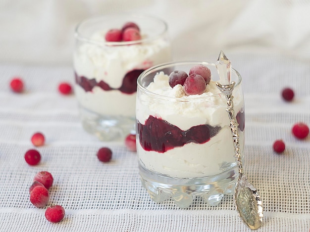 Foto dessert met veenbessen en room in glas op witte tafel close-up gezonde voeding dieet