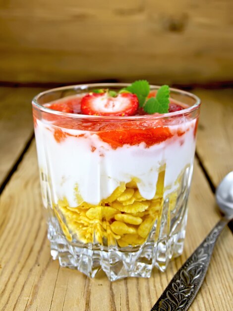 Photo dessert milk with strawberry in glassful on board