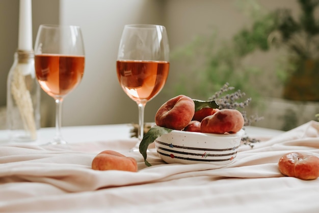 Dessert peaches and glass of wine on minimal white background