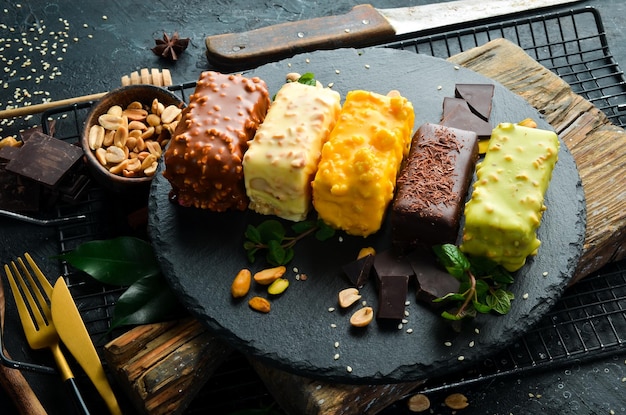 Dessert Set of colored cookies with chocolate cream caramel and pistachios Candy bar Top view Rustic style