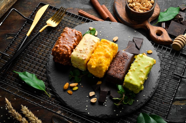 Десерт набор цветного печенья с шоколадно-кремовой карамелью и фисташками шоколадный батончик вид сверху деревенский стиль