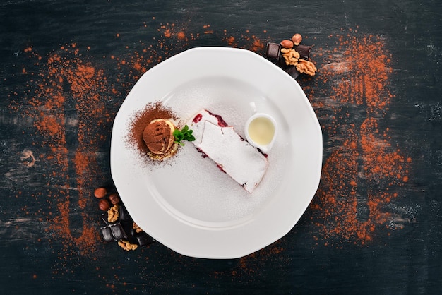 Dessert Strudel with berry jam and ice cream on a plate On a wooden background Top view Copy space