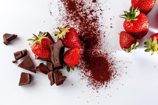 Dessert sweet strawberries with chocolate and what on a white background Top view