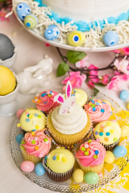 Dessert table set with cake and cupcakes for Easter brunch.