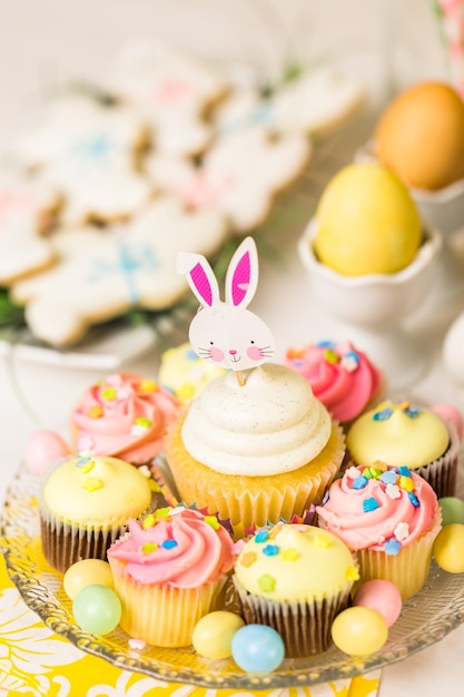 Dessert table set with cake and cupcakes for Easter brunch.