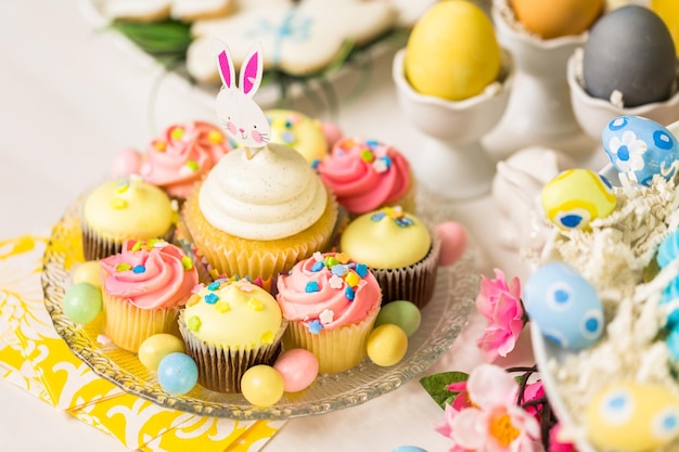 Dessert table set with cake and cupcakes for Easter brunch.