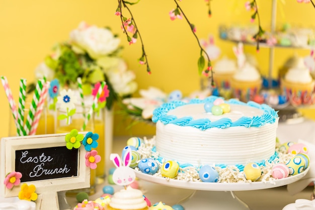 Dessert table set with cake and cupcakes for Easter brunch.