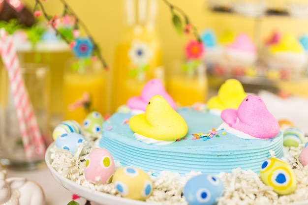 Dessert table with Easter cake decorated with traditional Easter marshmallow chicks.