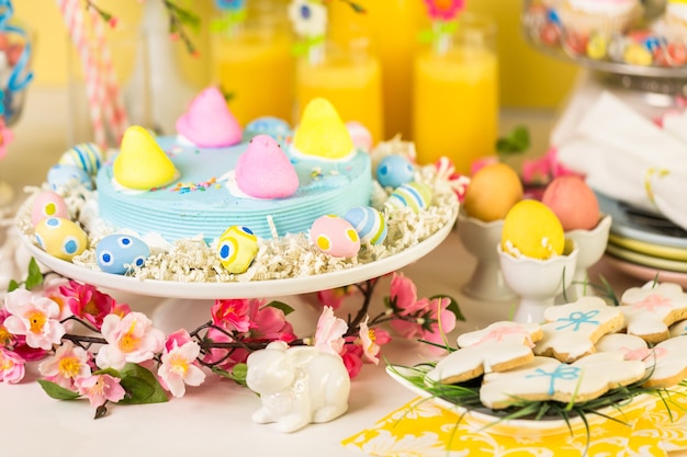 Dessert table with Easter cake decorated with traditional Easter marshmallow chicks.