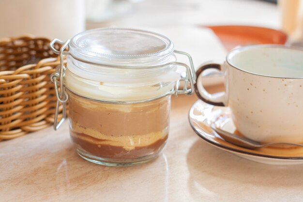 Dessert three chocolates in a jar and a cup on the table in a restaurant