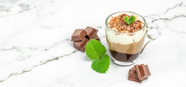 Dessert three chocolates pudding decorated with mint on a light background Layered delicious dessert Long banner format