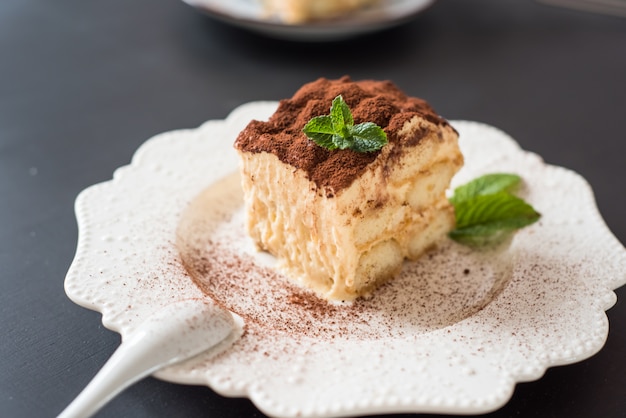 Dessert tiramisu cake decorated mint on black background