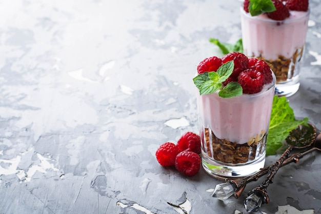 Dessert with granola, yogurt and raspberry. Selective focus