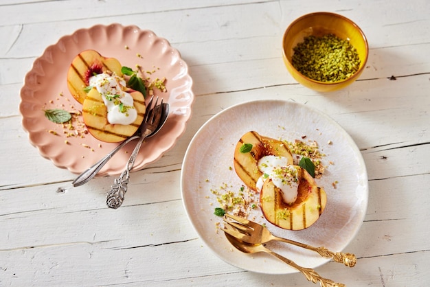 Dessert with grilled peaches and yogurt on plates