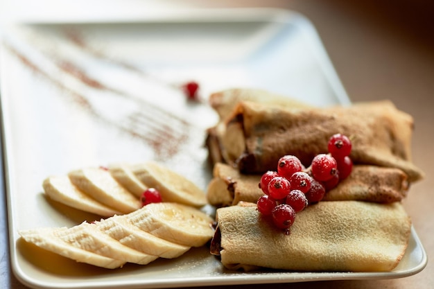 Desserthot pancakes with chocolate spread and banana Decorated with currantsSweet dessert