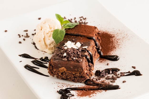 Dessertmenu van het restaurant. Zoete brownie op witte plaat close-up.