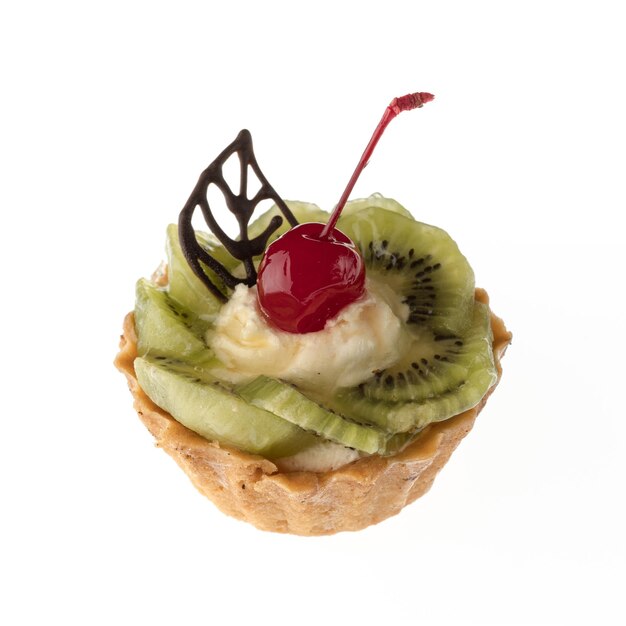 Desserttaart met kiwi en kersen op een wit bord geïsoleerd