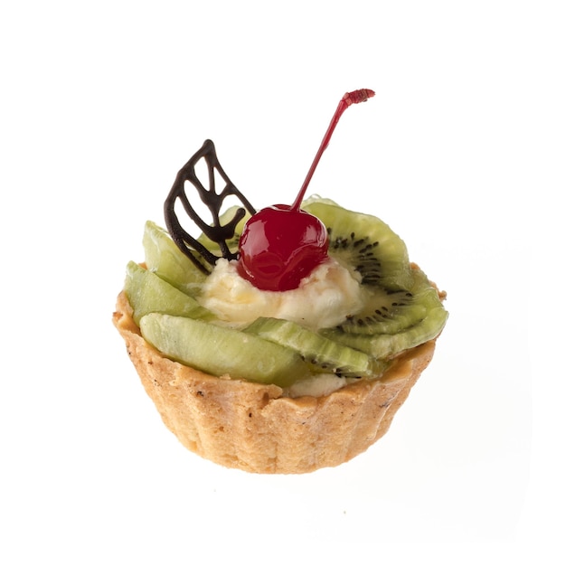 Desserttaart met kiwi en kersen op een wit bord geïsoleerd