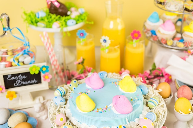 Desserttafel met paastaart versierd met traditionele paasmarshmallow-kuikens.