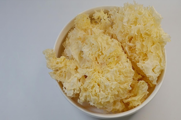 Photo dessicated snow or white fungus tremella fuciformis in a bowl isolated on white