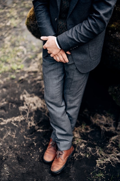 Destination iceland wedding closeup of male legs in gray trousers and leather brown shoes