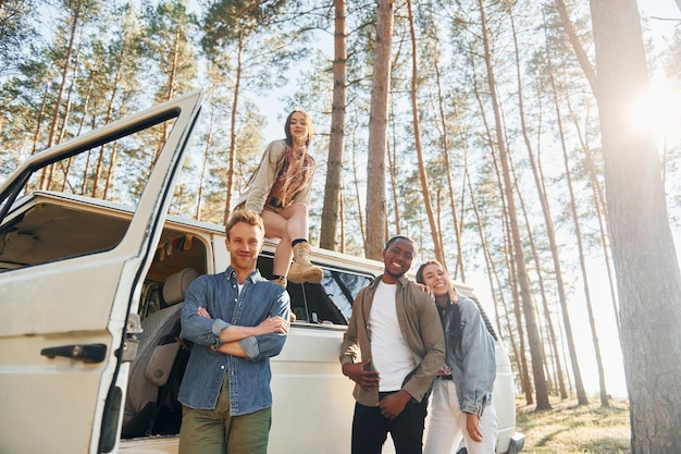 Destination place group of young people is traveling together\
in the forest at daytime