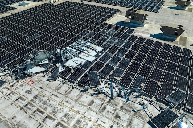 Photo destroyed by hurricane winds broken down photovoltaic solar panels mounted on industrial building roof for producing green ecological electricity consequences of natural disaster in florida