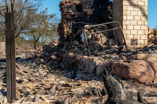 Destroyed houses as a result of a fire in russia bricks and\
parts of walls various household items broken windows covered with\
ash lie on the surface of the earth natural disaster