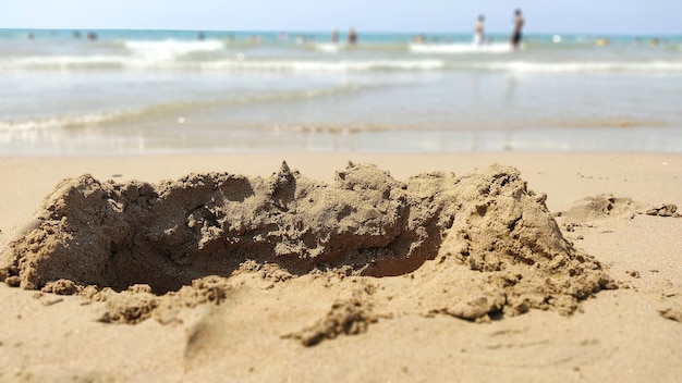 Castello distruttivo dell'onda sulla sabbia in riva al mare. vacanza