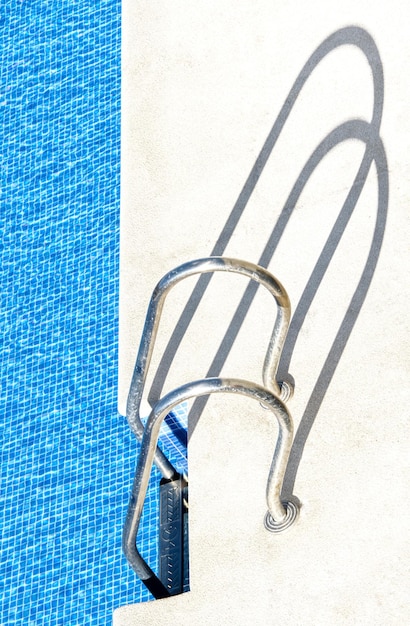 Detail of the access ladders to a pool of transparent water.